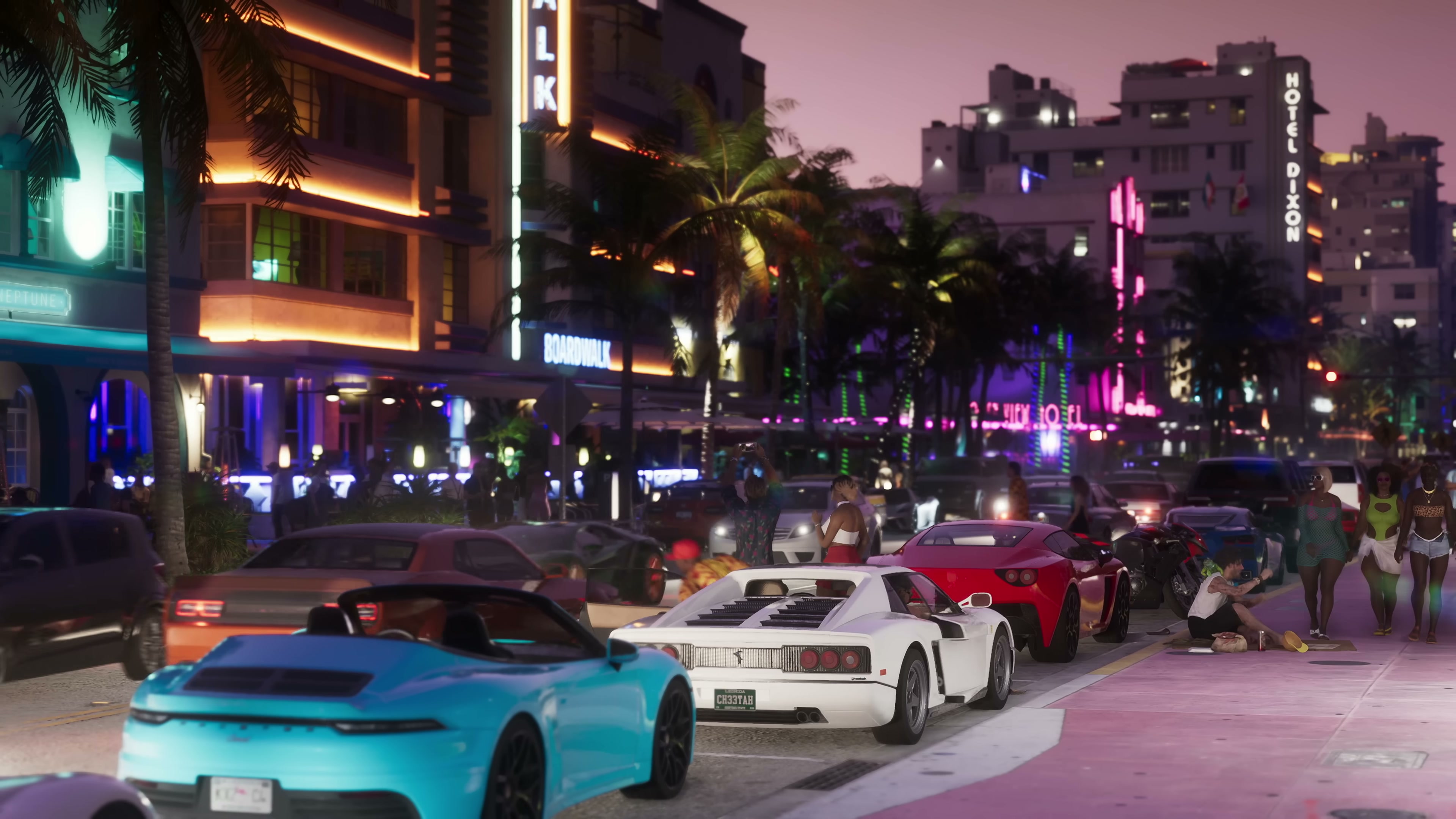 Neon-lit Art Deco hotel strip in Vice City at night with parked sports cars and crowds on the sidewalk.