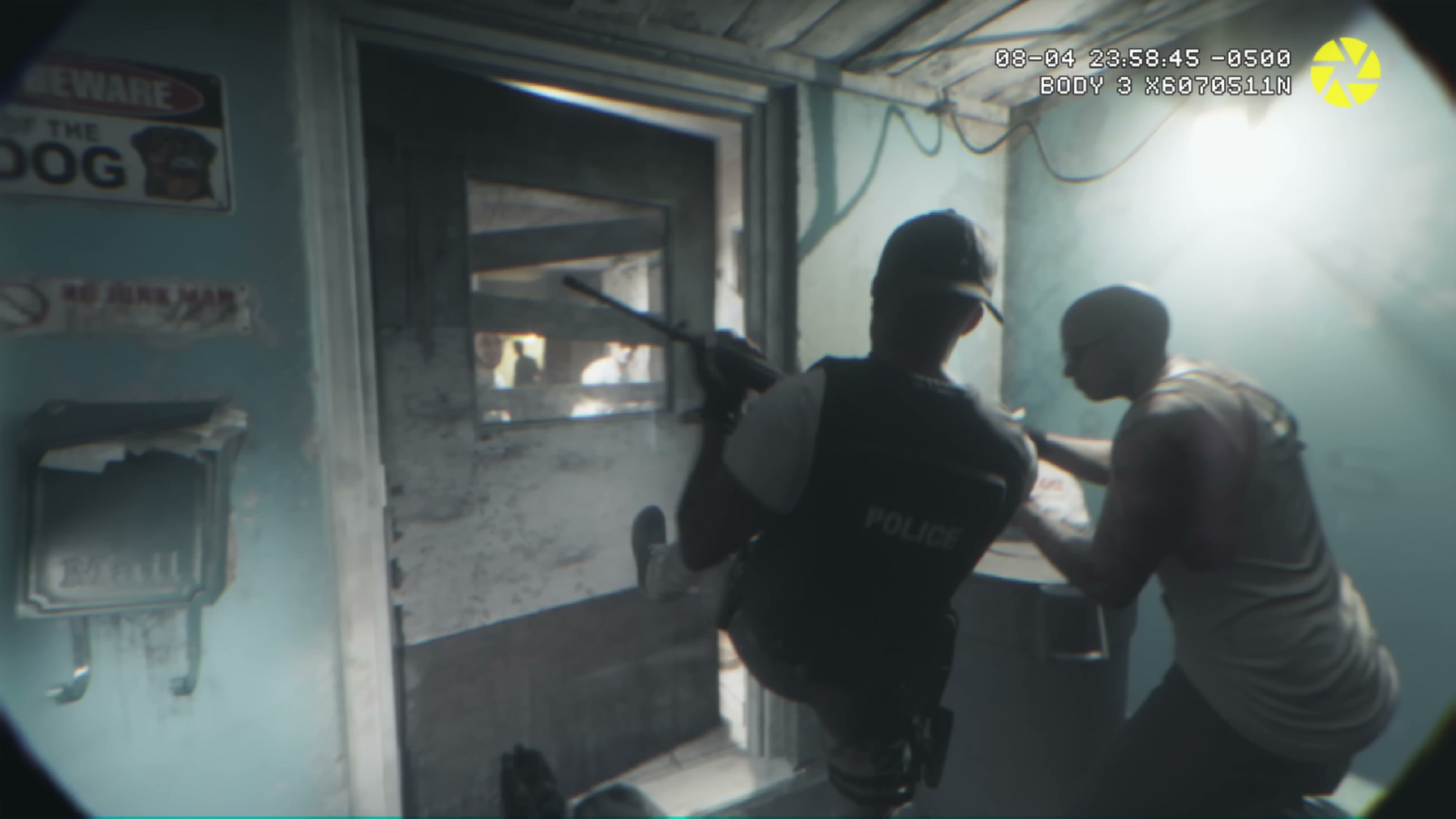 Police bodycam interior raid scene with rifle aimed through doorway