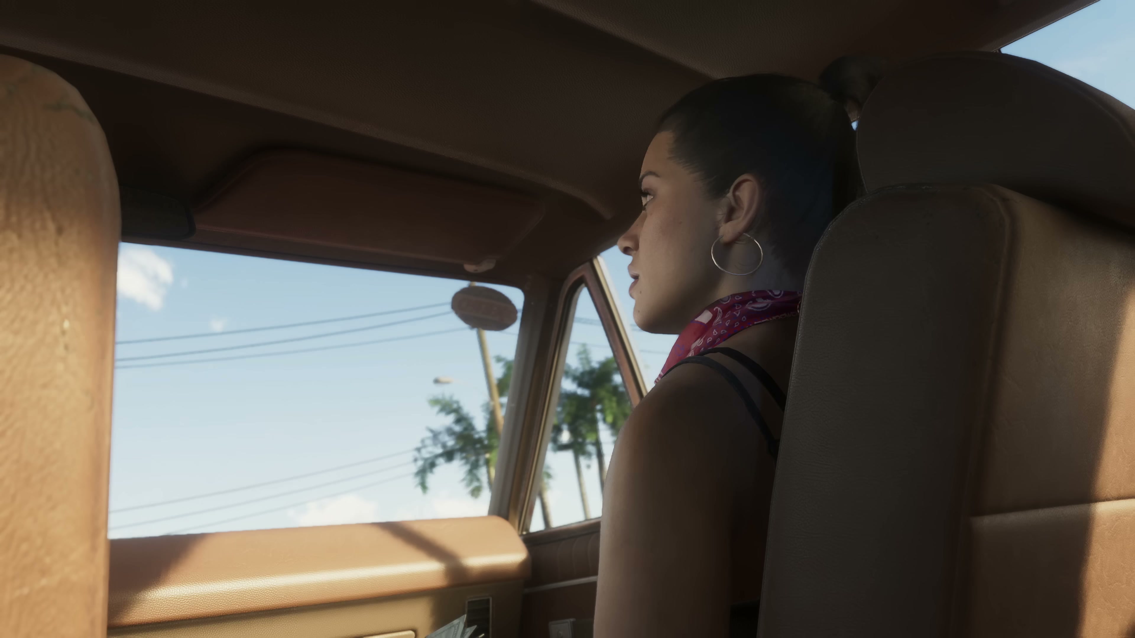 Side-profile interior shot of Lucia in a moving car, wearing a hoop earring and red bandana, with palm trees visible through the windshield