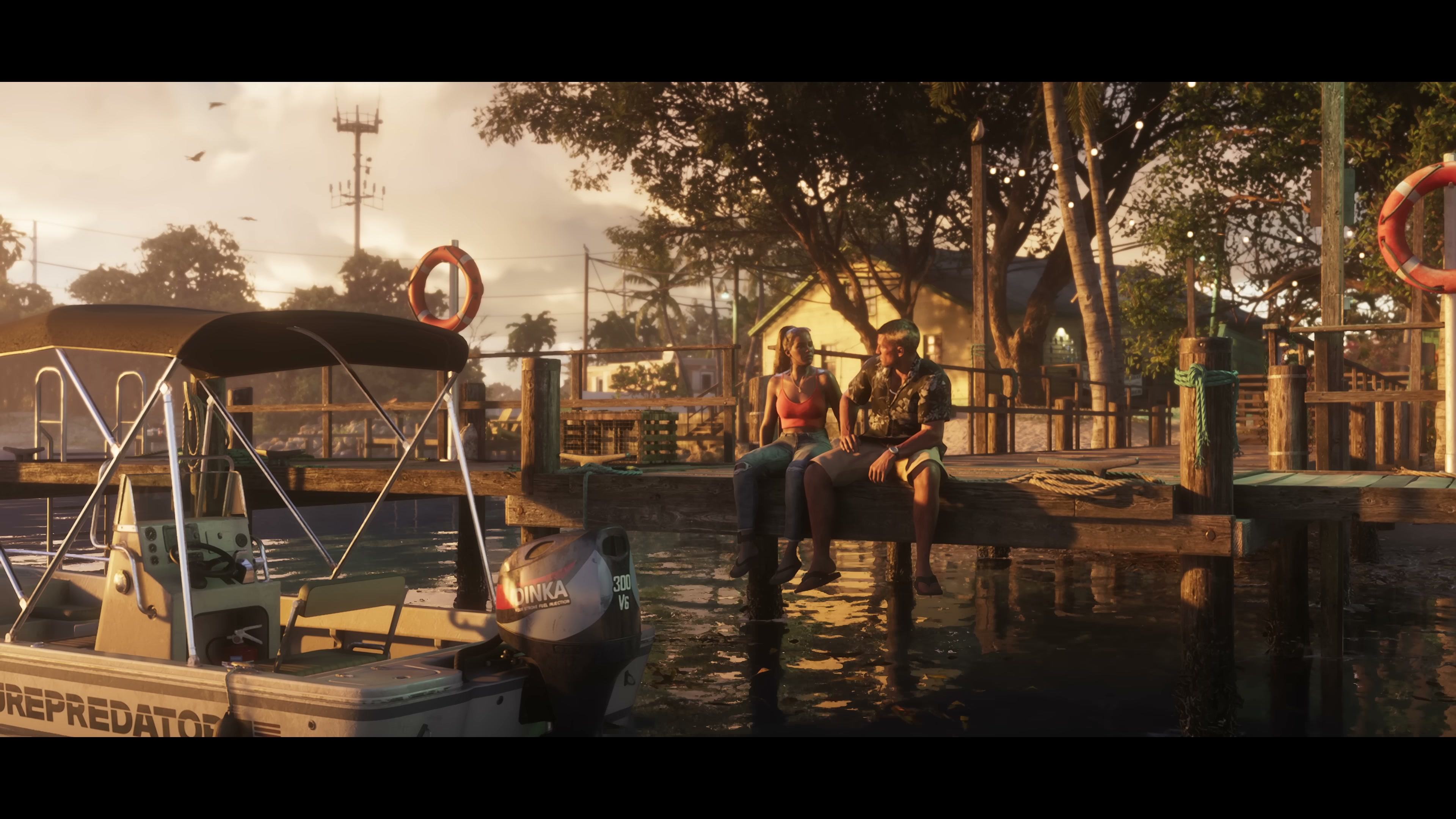 Jason and Lucia sit on a wooden dock at sunset, with a motorboat moored in the foreground